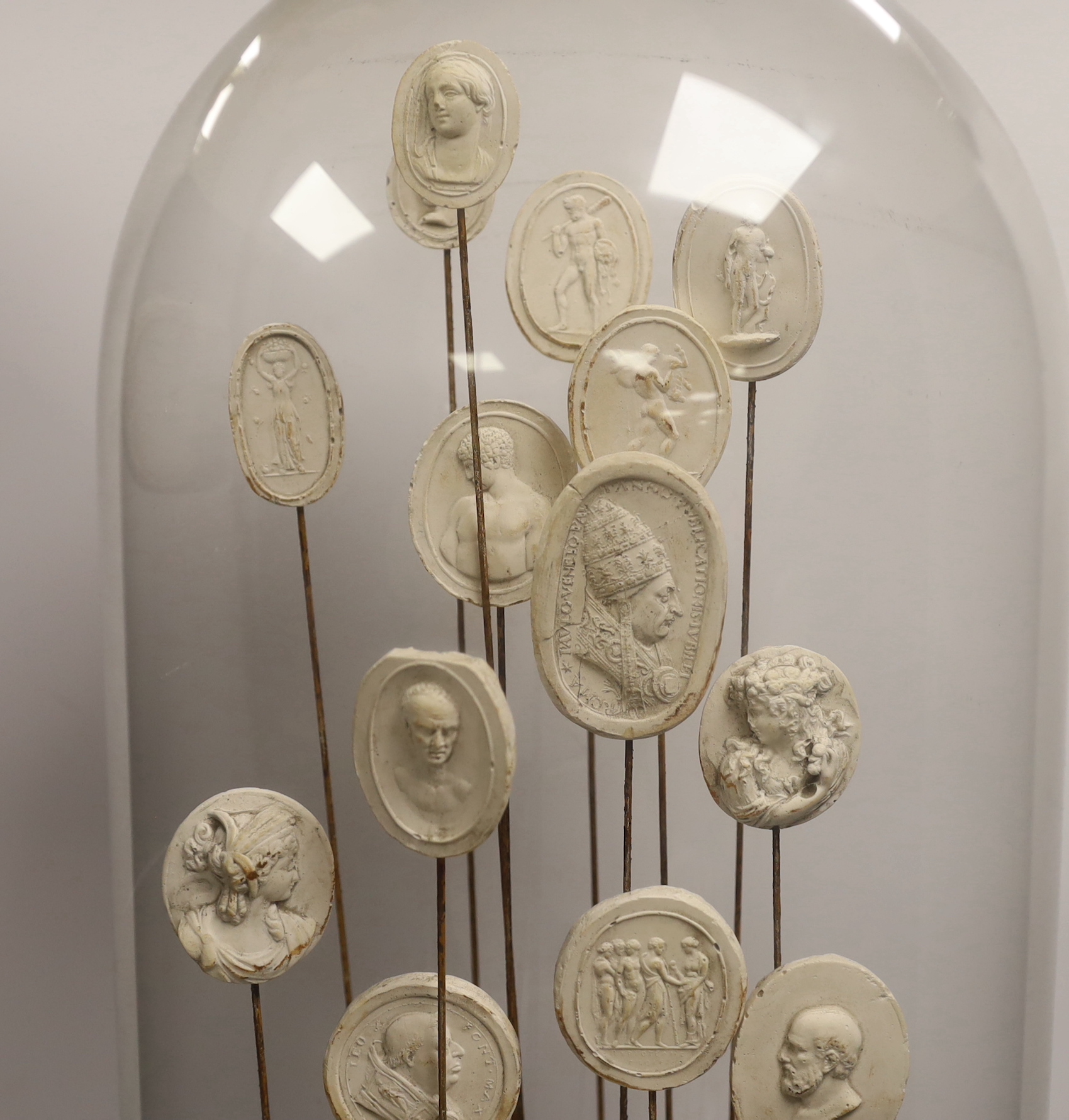 Twenty two Grand Tour intaglio reliefs, under glass dome, height 63cm.